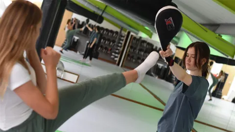Kickboxtraining: Eine Schülerin tritt gegen die Schlagpratze ihrer Trainingspartnerin